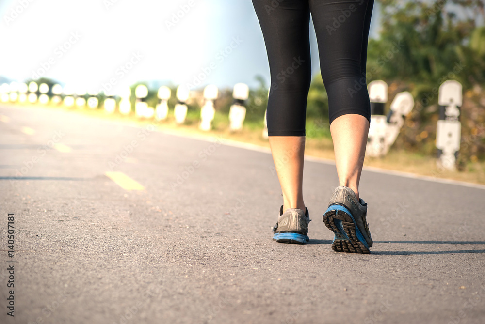 Close up leg of runner woman use running shoes jogging on road Close up leg of runner woman use running shoes jogging on road