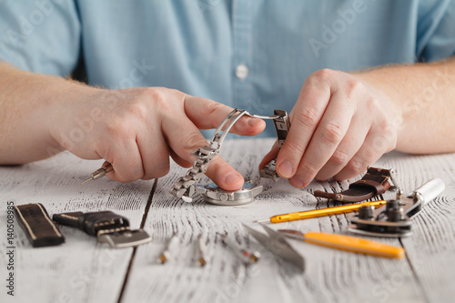 Male hold stainless watch and change watchband by hand