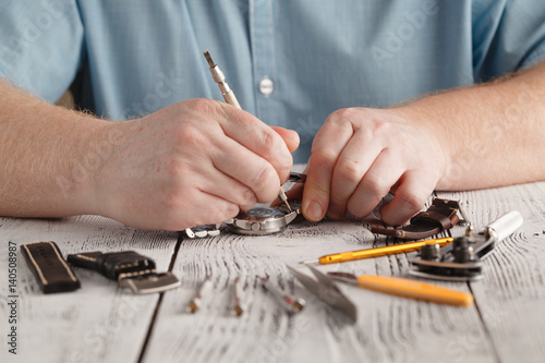 фотографія Male hold stainless watch and change watchband by hand