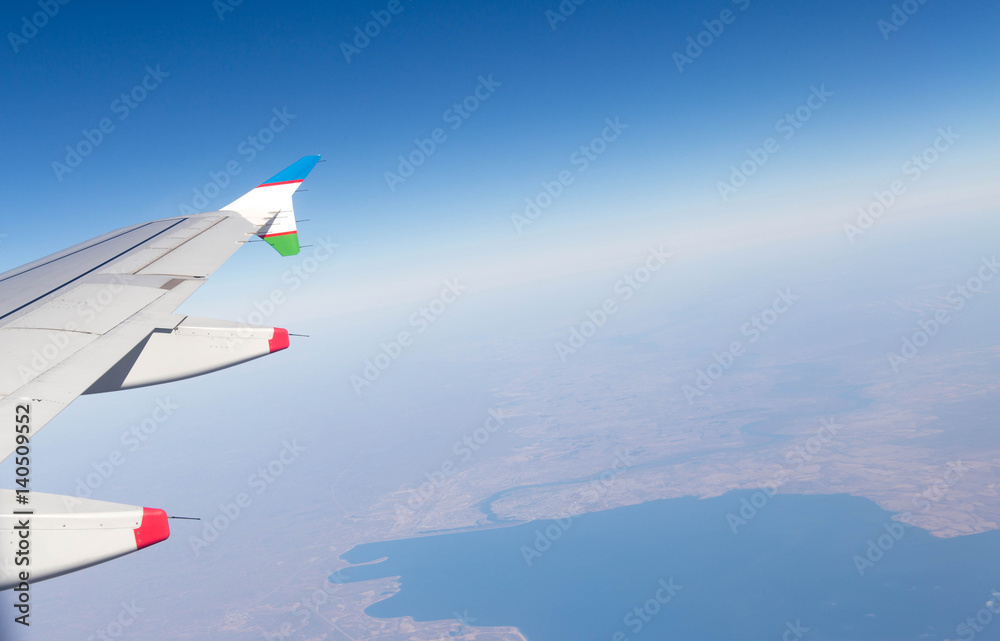 Fototapeta premium Clouds mountains and sky as seen through window of an aircraft of uzbekistan