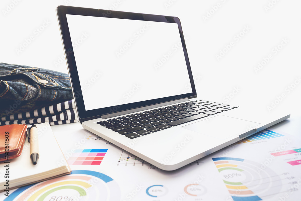 Laptop with paper graph and stationary on table Laptop with paper graph and stationary on table