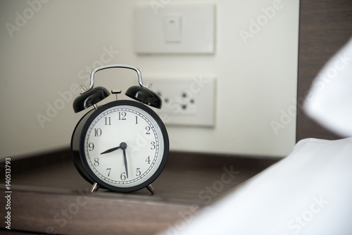 alarm clock on bed side table