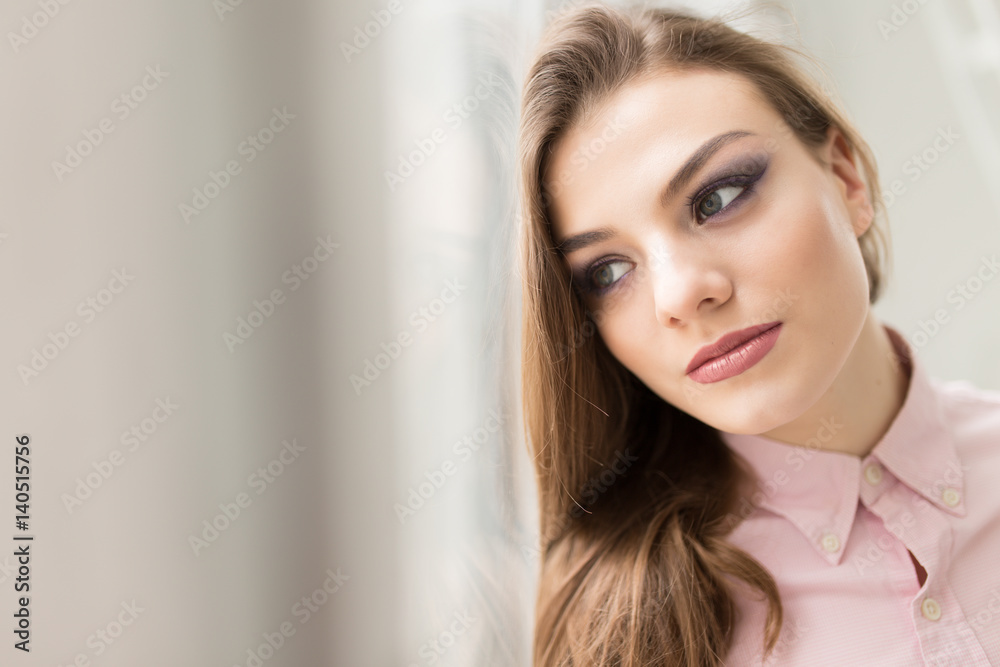 Beauty portrait of woman at window close-up