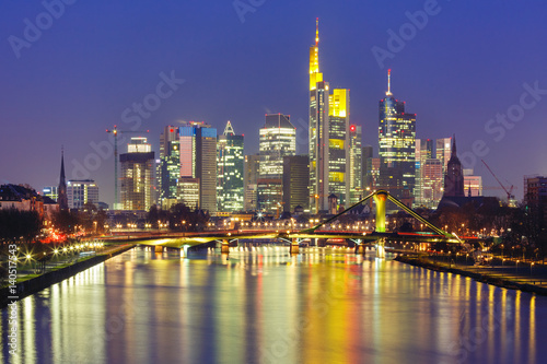 Picturesque view of business district with skyscrapers and mirror reflections in the river during morning blue hour  Frankfurt am Main  Germany