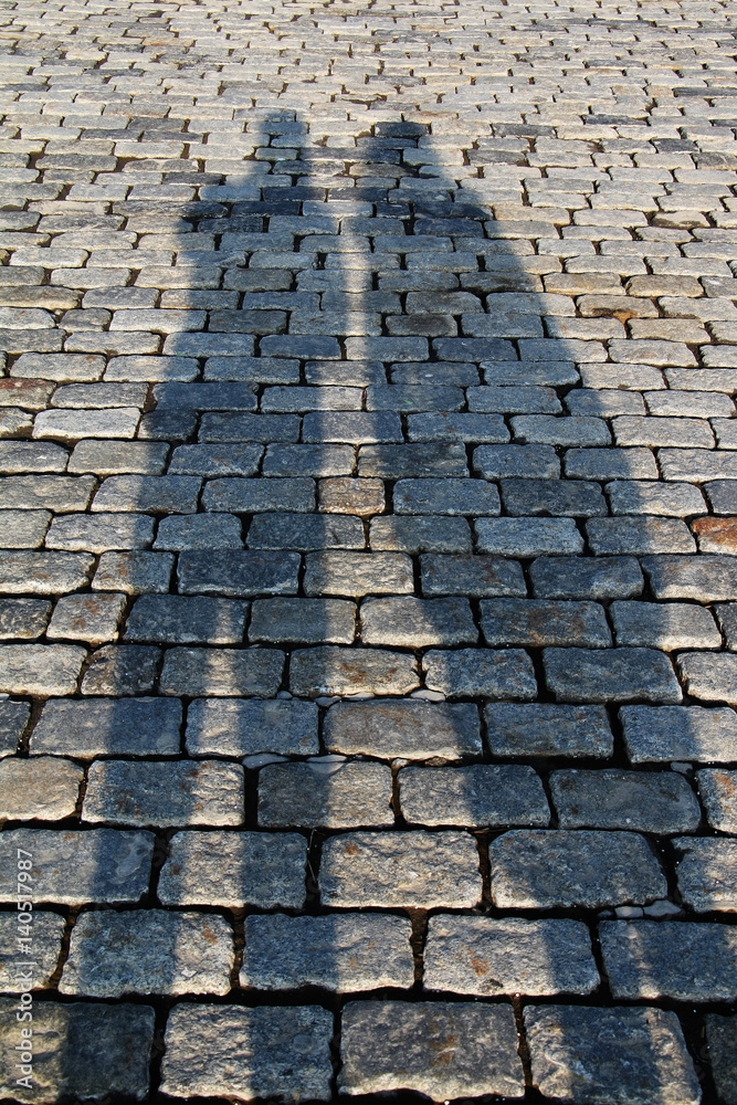Shadows of a loving couple in the city center on the cobblestones on a sunny day.