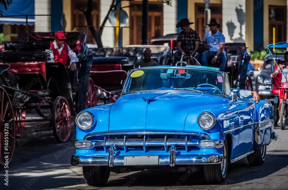 Amerikanischer blauer Cabriolet Oldtimer fährt durch Havanna Kuba - Serie Kuba Reportage
