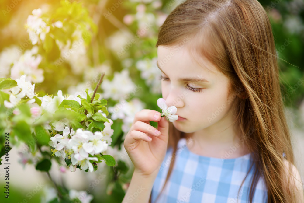 Adorable little girl in blooming apple tree garden on beautiful spring day Adorable little girl in blooming apple tree garden on beautiful spring day
