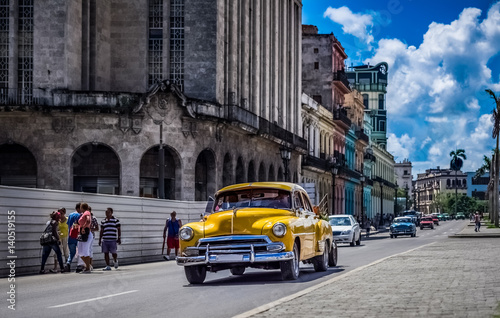 Fototapeta Naklejka Na Ścianę i Meble -  HDR - Kuba amerikanische gelber Chevrolet Oldtimer fährt auf der Hauptstrasse von Havanna City in Kuba- Serie Kuba Reportage