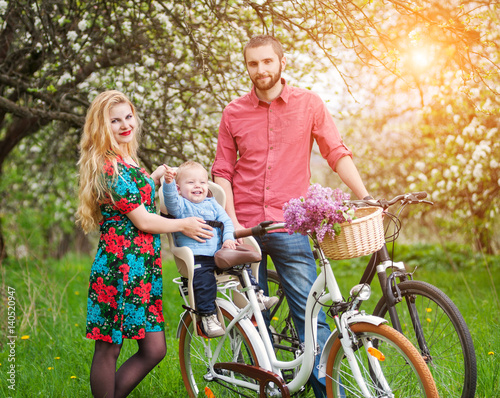 Young family on a bicycles in the spring garden © anatoliy_gleb