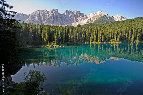 Fototapeta Naklejka Na Ścianę i Meble -  Lago di Carezza, an extremely clear lake in the Dolomites of Northern Italy. Visibility more than 30 feet down to see logs, fish and sand. Also known as Rainbow Lake.