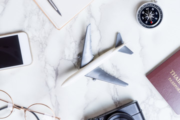 Airplane with travel accessories on marble surface