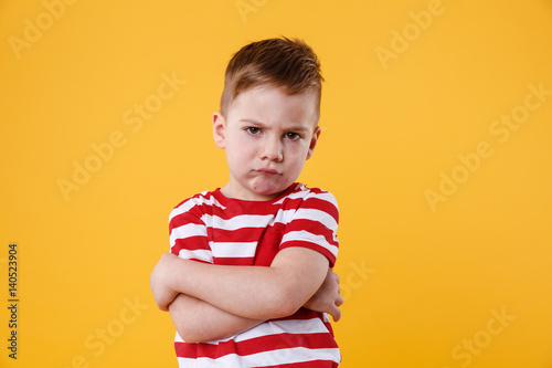 Tableau sur toile Portrait of a frowning upset little boy looking at camera