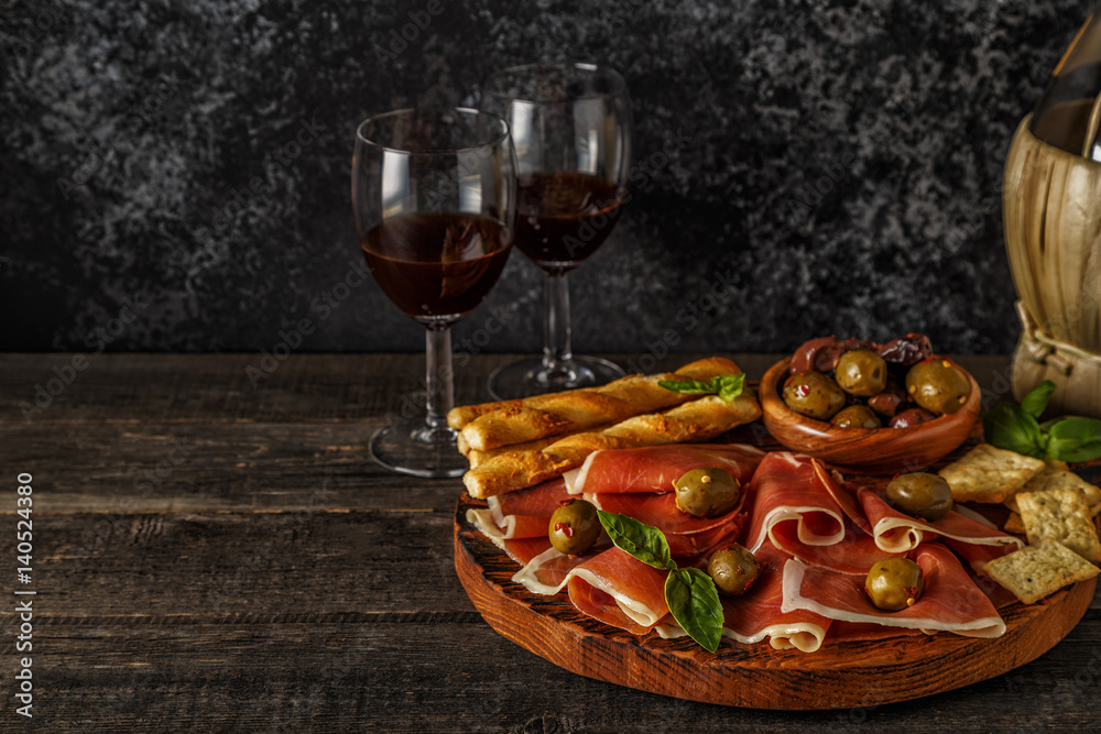 Prosciutto, cracker, bread sticks with red wine.