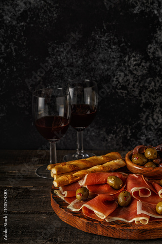 Prosciutto, cracker, bread sticks with red wine.