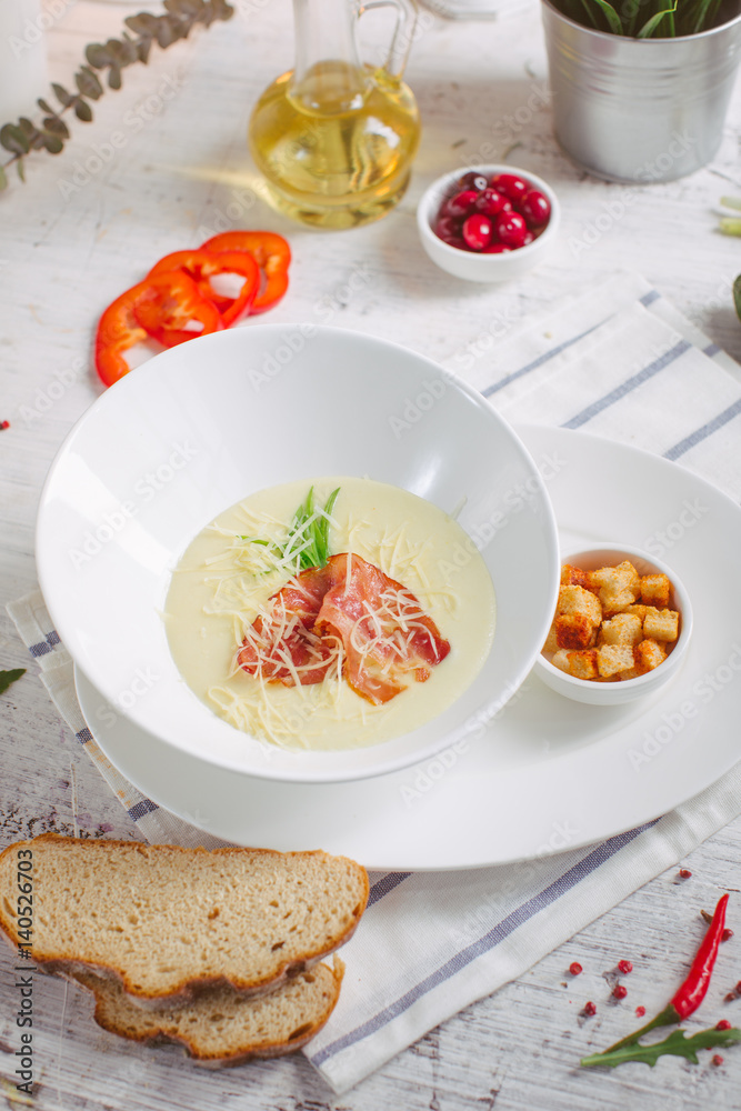 Cream soup with parmesan and bacon and crackers Cream soup with parmesan and bacon and crackers