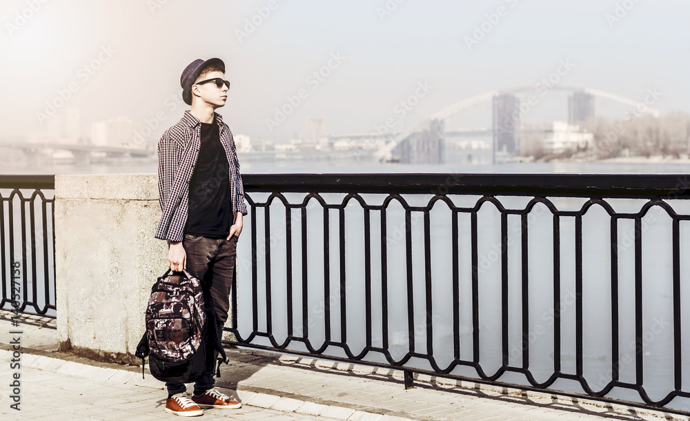 Obraz premium Stylish young man on the city embankment