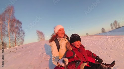 happy family rides and smiling snowtube on snowy roads.slow motion. snow winter landscape. outdoors sports.Sunset