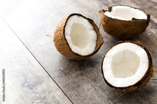 Half coconuts fruit on wooden background 