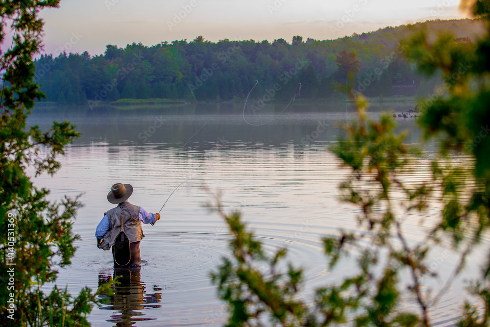 Young man flyfishing at sunrise