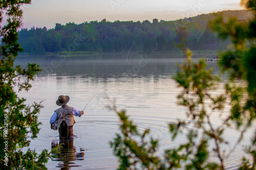 Obraz na płótnie Young man flyfishing at sunrise w salonie