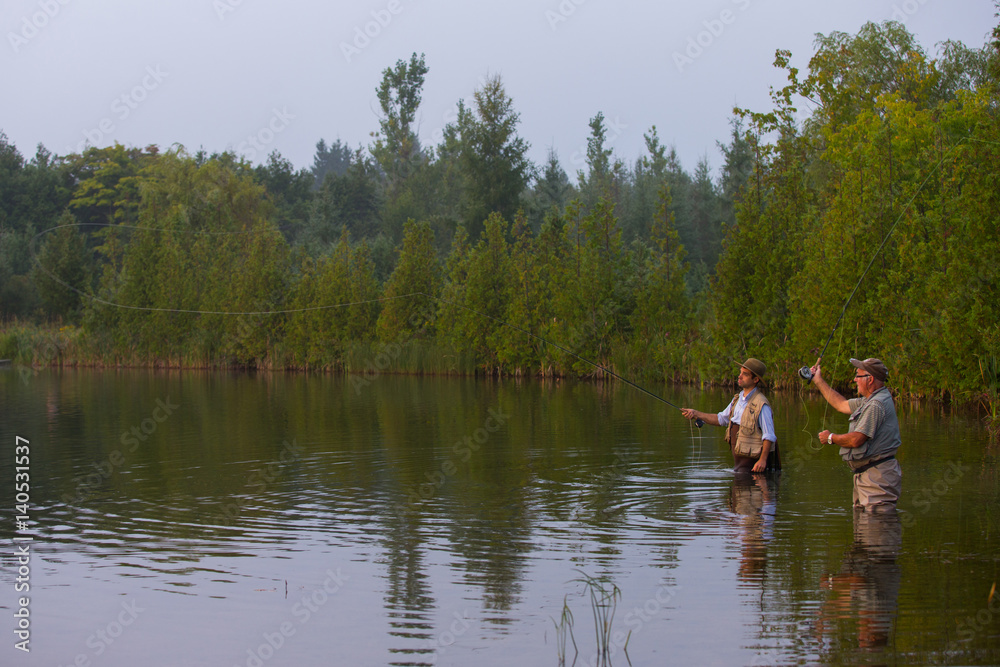 Father and son flyfishing at sunrise