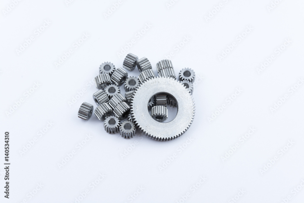 Isolated metal pinions gear. The iron gear on a white background. Pinions in the gearbox. Parts to the gear mechanism. Sprockets to clockwork. Shiny gear ready for assembly. Isolated metal pinions gear. The iron gear on a white background. Pinions in the gearbox. Parts to the gear mechanism. Sprockets to clockwork. Shiny gear ready for assembly.