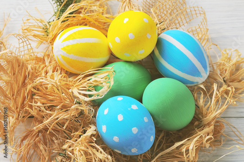 Easter eggs in the nest on rustic white background