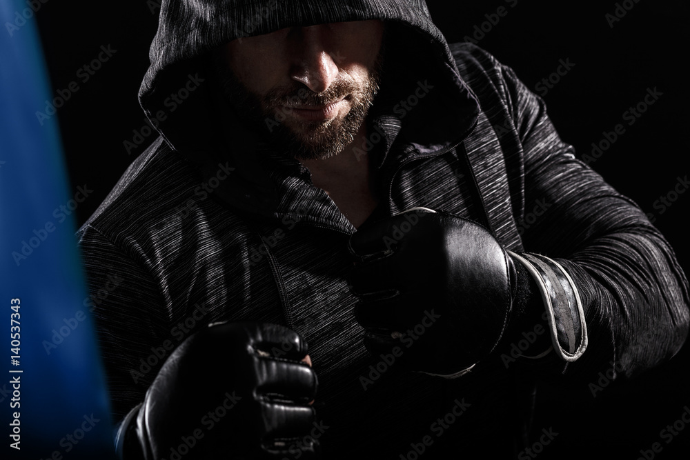 Studio shot of male boxer punching a boxing bag. Studio shot of male boxer punching a boxing bag.
