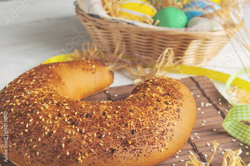 Easter eggs in the nest and bread on rustic white background. Traditional easter cake