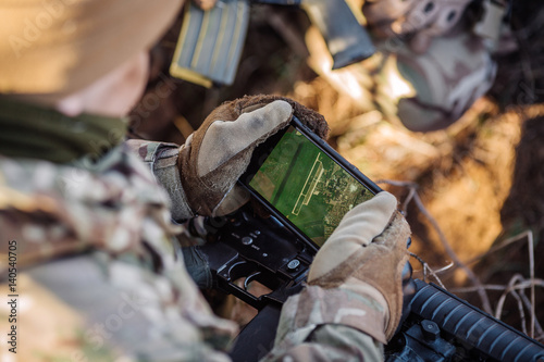 soldiers holding gps in hand and determines the location of coordinates
