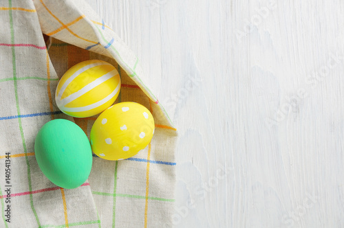 Close up decorating Easter eggs and napkin. rustic white background