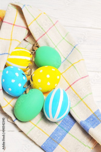 Close up decorating Easter eggs and napkin. rustic white background