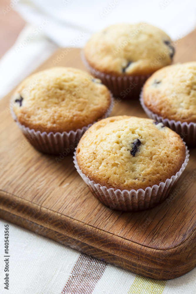 Homemade muffins with blueberries on a wooden board Homemade muffins with blueberries on a wooden board