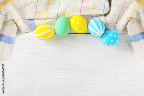 Close up decorating Easter eggs and napkin. rustic white background