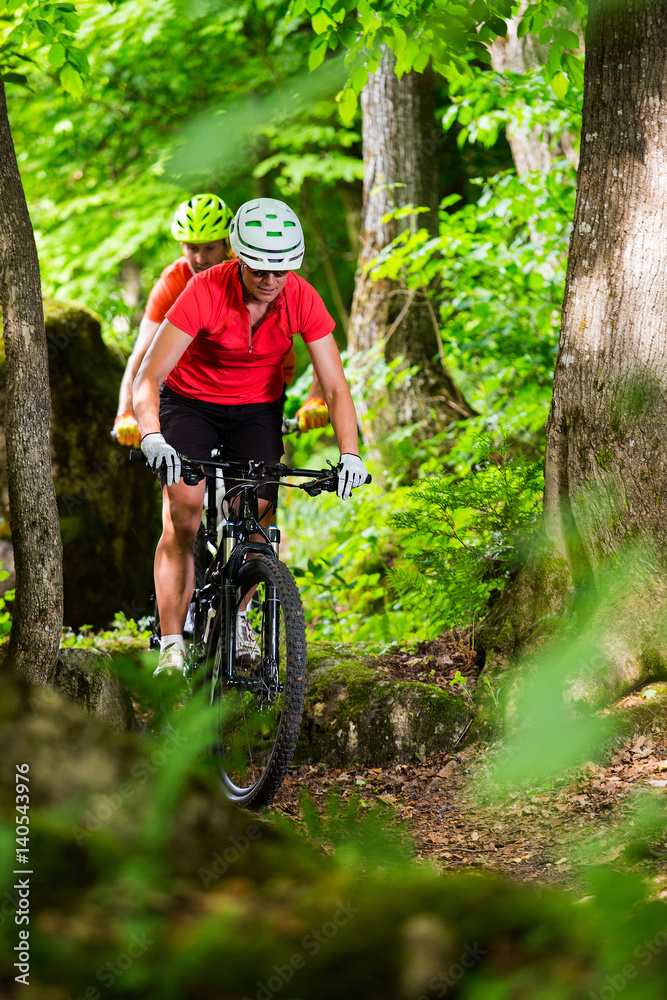 Fototapeta premium Couple Mountain Biking on Single Track in the Forest