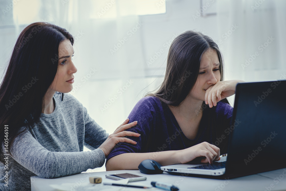 Scared mother arguing daughter over online activity. Cyber bullying or blue whale game concept Scared mother arguing daughter over online activity. Cyber bullying or blue whale game concept