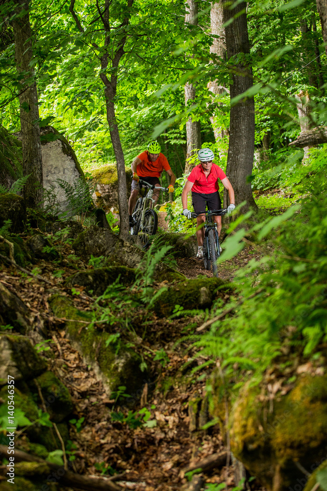 Couple Mountain Biking on Single Track in the Forest