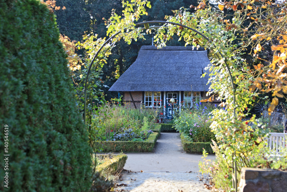 Strohdachhaus mit Bauerngarten im Hochsommer Strohdachhaus mit Bauerngarten im Hochsommer