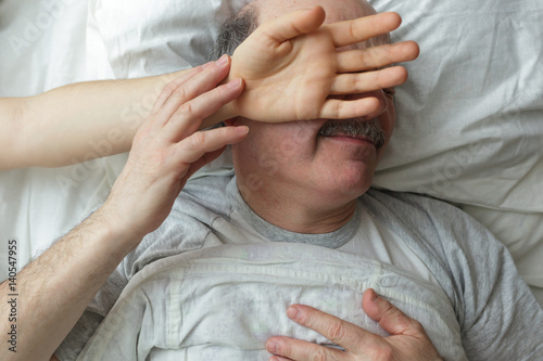 The wife put her hand on husband's face during sleep. 