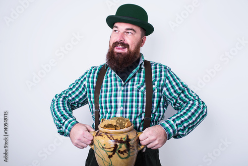 young man with pot of gold sitting  photo