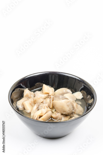 Sliced marinated mushrooms in the bowl isolated over white background