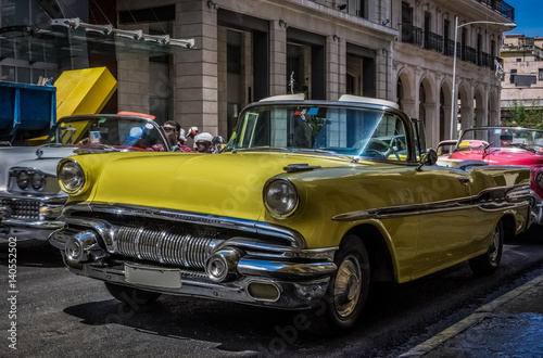 Fototapeta Naklejka Na Ścianę i Meble -  Gelber amerikanischer Cabriolet Oldtimer parkt in der Seitenstraße in Havanna Kuba  - Serie Kuba Reportage