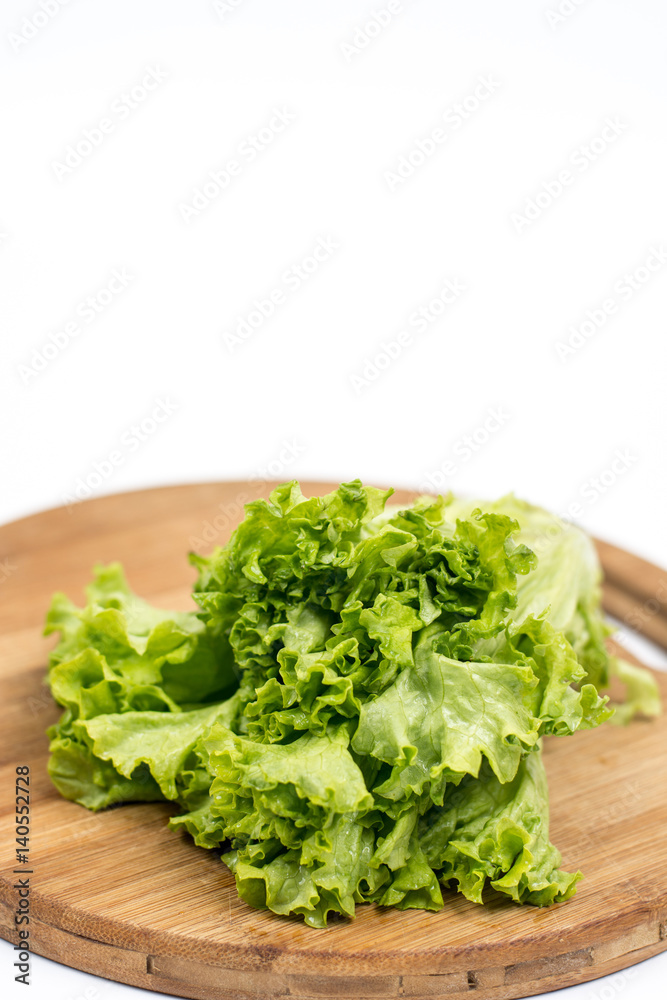 Green fresh raw lettuce isolated on the wooden board Green fresh raw lettuce isolated on the wooden board