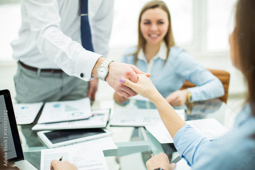 Bank Manager and the customer shake hands after signing a lucrative contract Bank Manager and the customer shake hands after signing a lucrative contract