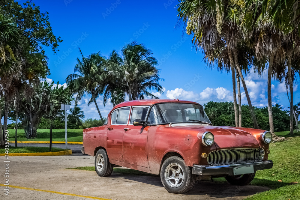 HDR - Roter alter Oldtimer parkt in varadero Kuba undter Palmen - Serie Kuba Reportage