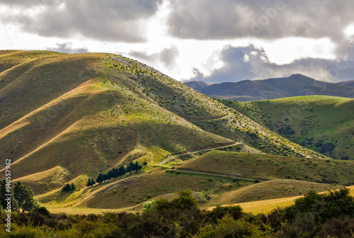Light and shadow on the rolling hills at Lindis Pass in Central Otago on the South island of New Zealand
