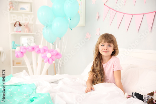 Cute birthday girl in bed a...