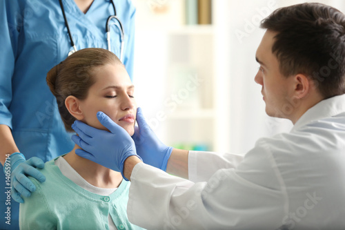 Young woman having meeting with plastic surgeon photo