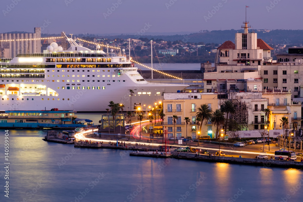 Old Havana at sunset with a view of historic buildings and a modern cruise ship docked on the bay