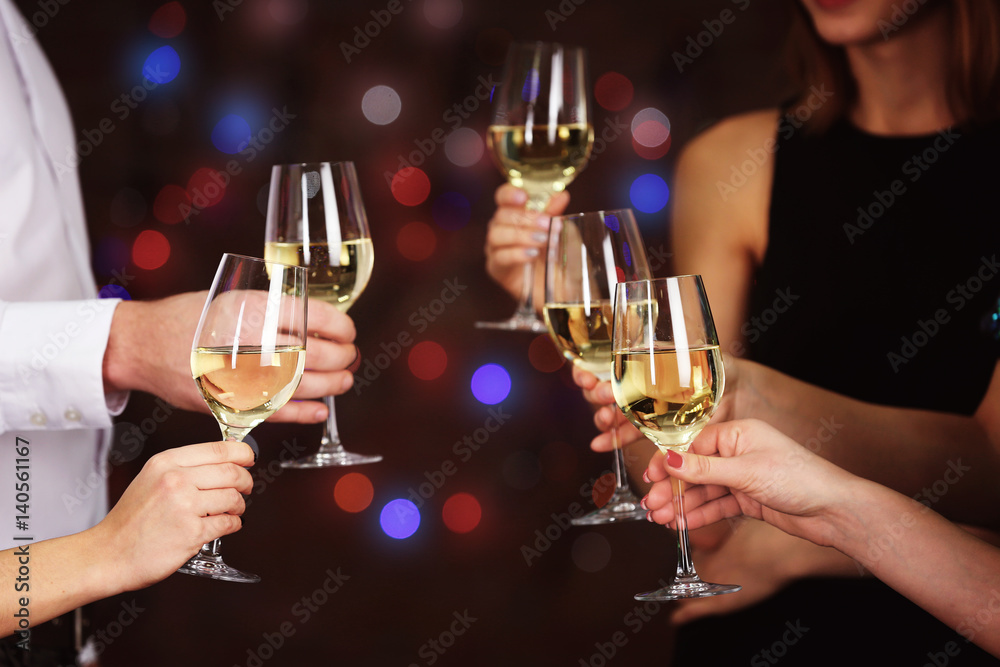People clinking glasses at party against defocused lights People clinking glasses at party against defocused lights